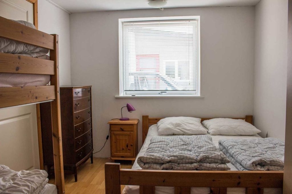 Lejlighedens eneste soveværelse med dobbeltseng, køjeseng og stort klædeskab