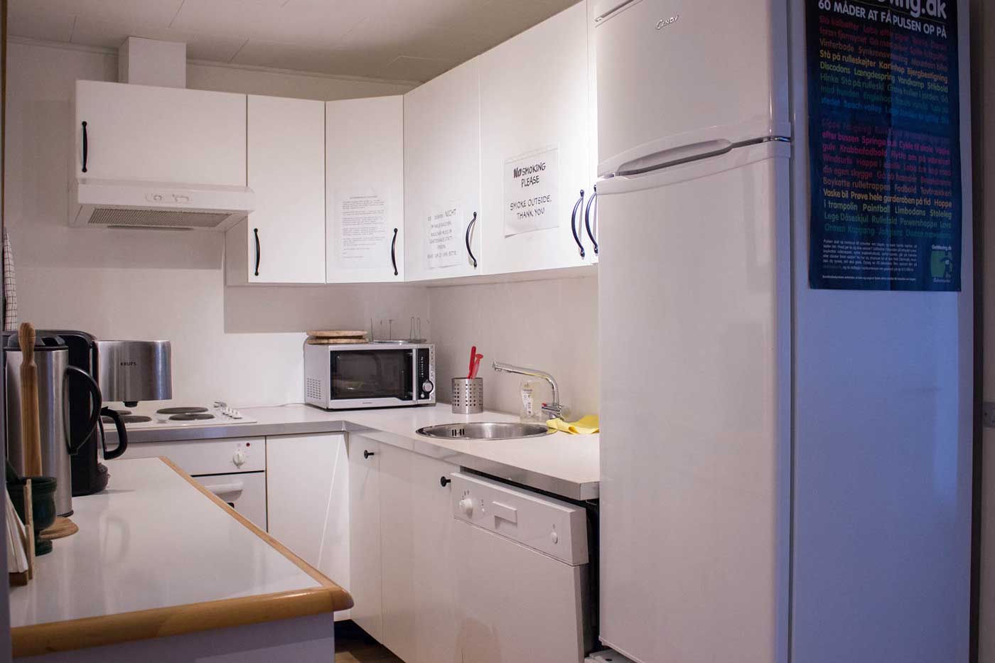 Køkkenet med kølefryseskab, mikroovn, elkedel, kaffemaskine, opvaskemaskine mv.